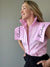 Blusa marfil con detalles bordados en  las solapas de los hombros que le confieren un aire artesanal y atractivo. La blusa de un color rosa claro. Una prenda de vestir para mujer elegante.
