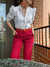 Modelo combina pantalon color cereza largo con camisa blanca 