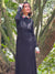 Modelo en un vestido negro largo elegante combiando el conjuno de cuello y puño blanco con detalle de corazones rojos bordados que destaca en todo el oufit y aporta color a todo el look.